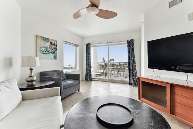 tiled living room with ceiling fan