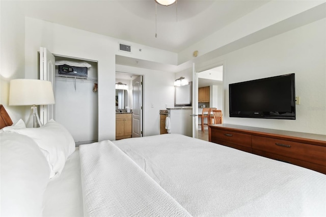 bedroom featuring ensuite bathroom, a closet, and hardwood / wood-style flooring