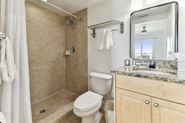 bathroom with a textured ceiling, vanity, toilet, and walk in shower