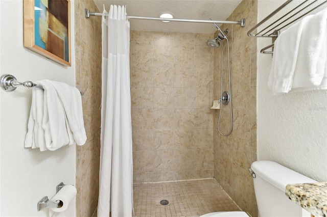 bathroom featuring curtained shower, toilet, and a textured ceiling