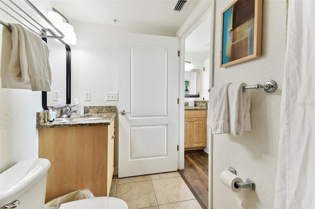 bathroom with hardwood / wood-style floors, vanity, and toilet