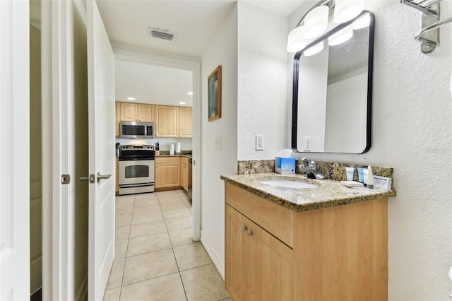 11605 Gulf Blvd Unit 507, Treasure Island, FL 33706 - bathroom featuring vanity, tile patterned flooring, and a textured wall
