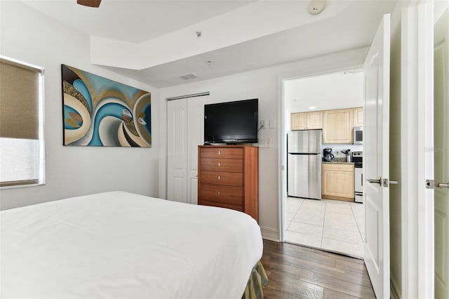 11605 Gulf Blvd Unit 507, Treasure Island, FL 33706 - bedroom featuring freestanding refrigerator, light wood-style flooring, and a closet