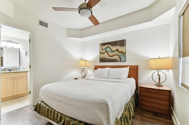 bedroom with light wood-type flooring, connected bathroom, and ceiling fan