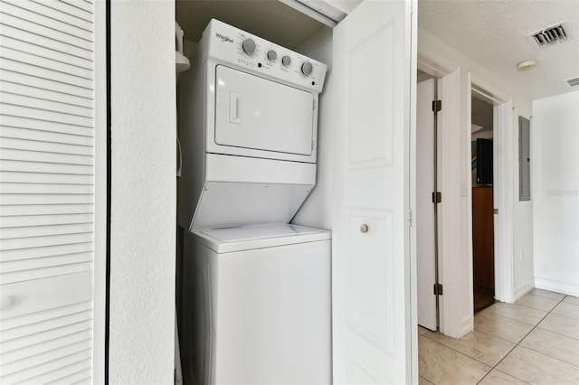 11605 Gulf Blvd Unit 507, Treasure Island, FL 33706 - laundry area featuring stacked washer / drying machine, light tile patterned floors, and electric panel