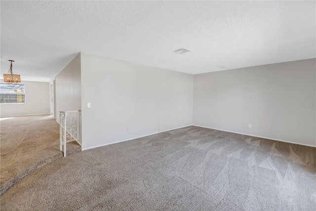 empty room featuring carpet floors and a textured ceiling