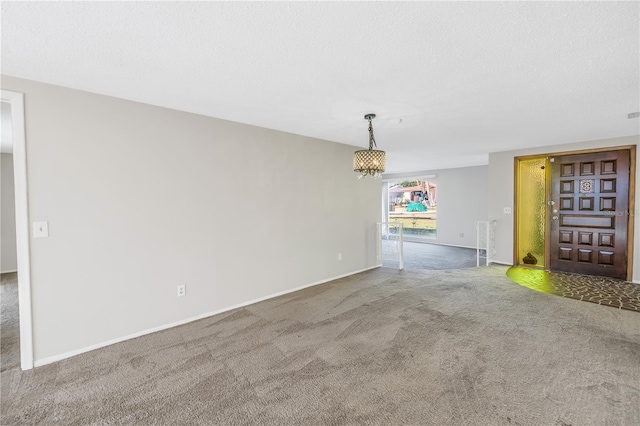 unfurnished living room with a chandelier, a textured ceiling, and carpet flooring