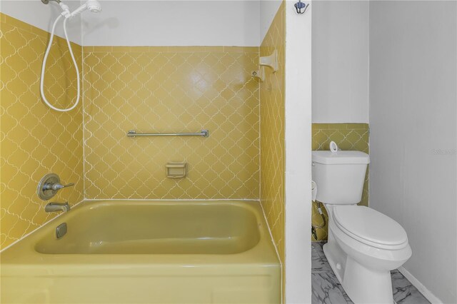 bathroom with toilet and tiled shower / bath combo