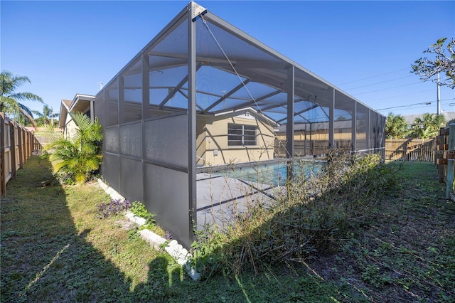 view of pool featuring a yard and glass enclosure