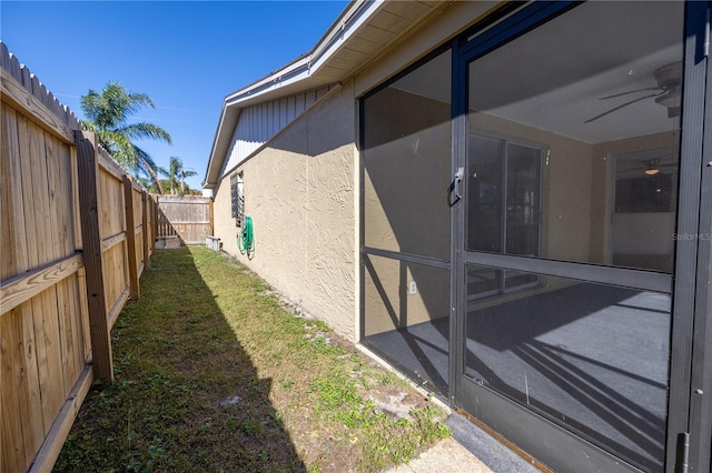 view of side of home featuring a lawn and ceiling fan