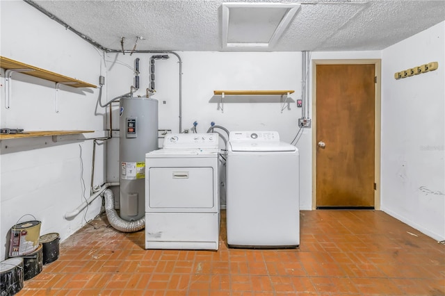 clothes washing area with washer and dryer, electric water heater, and a textured ceiling