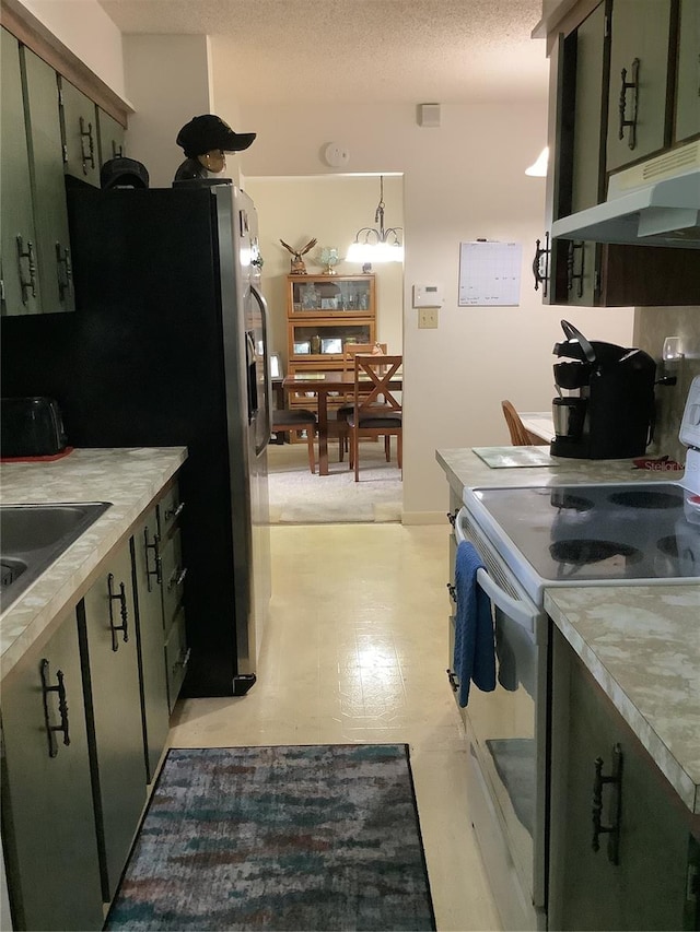 kitchen featuring sink, white range with electric cooktop, decorative light fixtures, a textured ceiling, and green cabinetry