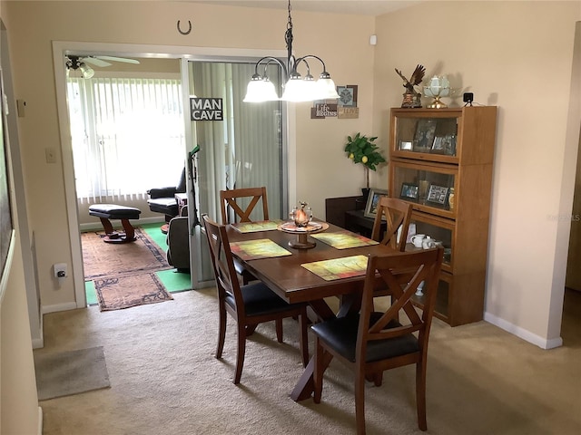 carpeted dining space with ceiling fan with notable chandelier