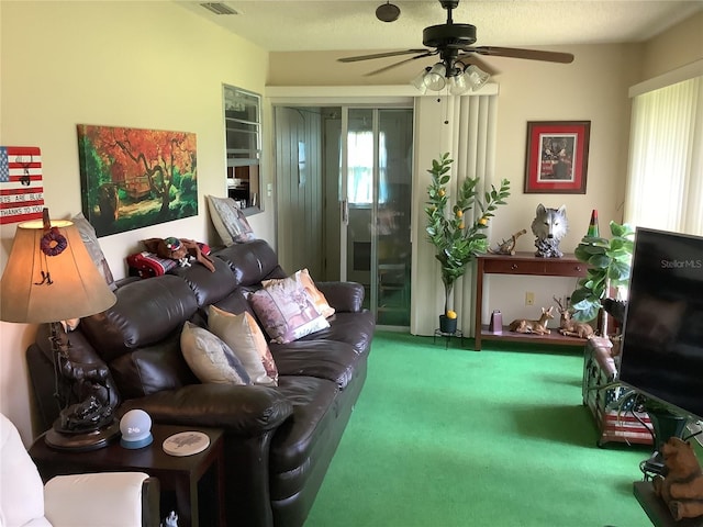 living room featuring carpet, a textured ceiling, and ceiling fan