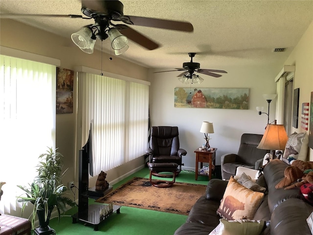 living room featuring ceiling fan, carpet floors, and a textured ceiling