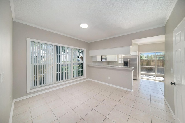 tiled spare room featuring a textured ceiling and crown molding