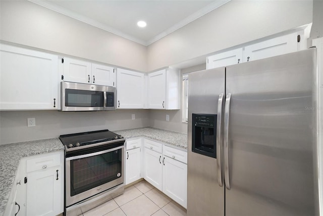 kitchen with light stone countertops, ornamental molding, stainless steel appliances, light tile patterned floors, and white cabinets