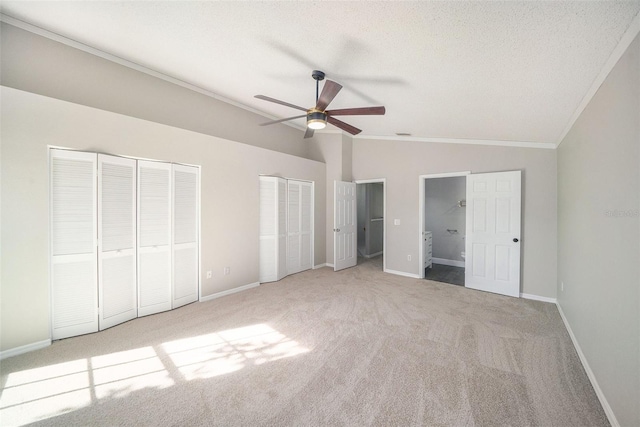 unfurnished bedroom featuring light carpet, a textured ceiling, ceiling fan, crown molding, and lofted ceiling