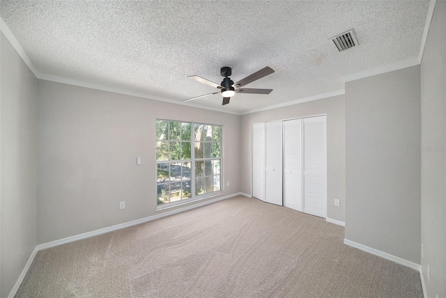 unfurnished bedroom with carpet flooring, a textured ceiling, a closet, and ceiling fan