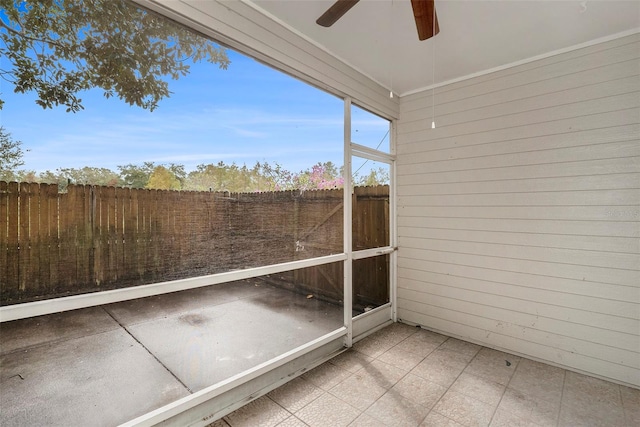 unfurnished sunroom featuring ceiling fan