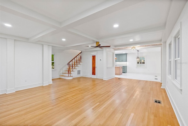 unfurnished living room with beamed ceiling, coffered ceiling, ceiling fan, and light hardwood / wood-style flooring