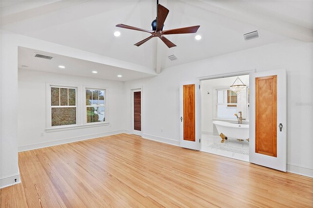 unfurnished living room featuring ceiling fan, high vaulted ceiling, and light wood-type flooring