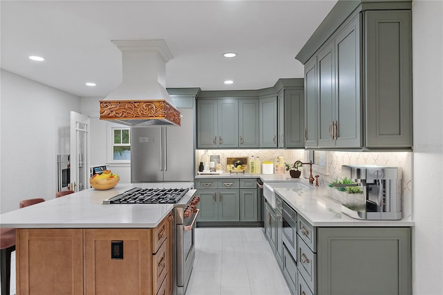 kitchen with sink, tasteful backsplash, a kitchen island, custom range hood, and stainless steel appliances