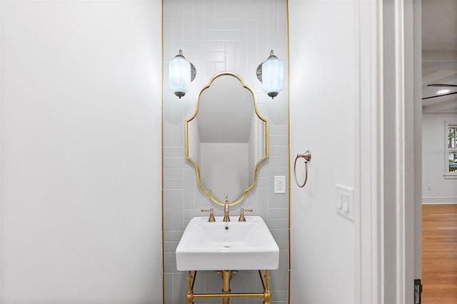 bathroom with hardwood / wood-style flooring, sink, and tile walls