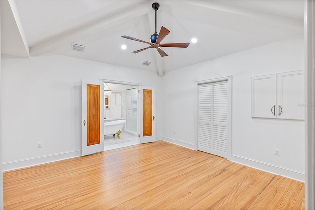 unfurnished bedroom featuring connected bathroom, light hardwood / wood-style flooring, lofted ceiling with beams, and a closet