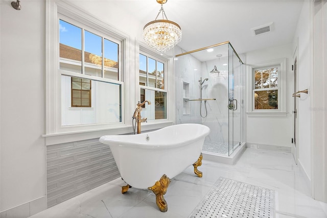 bathroom featuring a chandelier and separate shower and tub