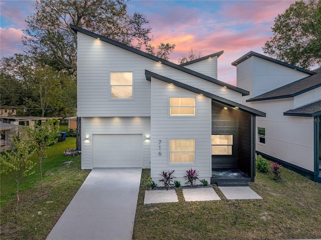 contemporary home with a garage and a lawn