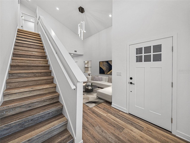 foyer entrance with dark hardwood / wood-style flooring and a high ceiling