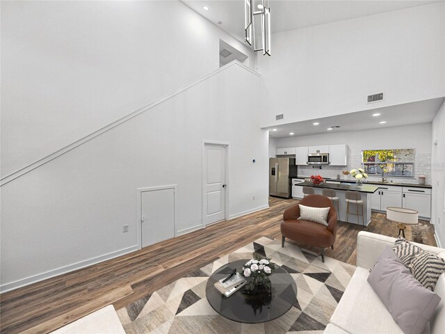 living room featuring wood-type flooring and a high ceiling