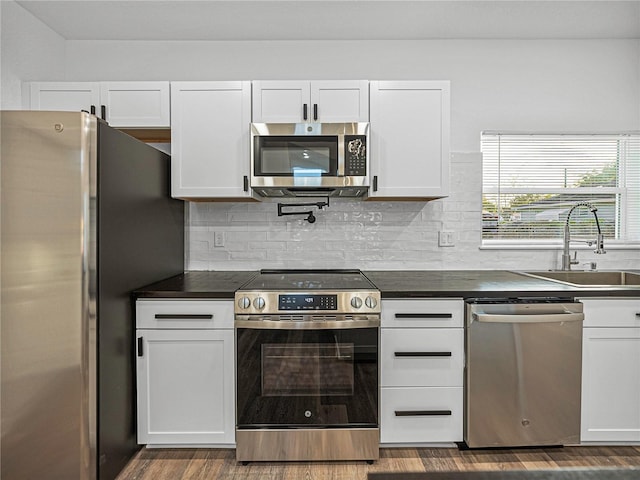 kitchen with sink, white cabinets, and appliances with stainless steel finishes