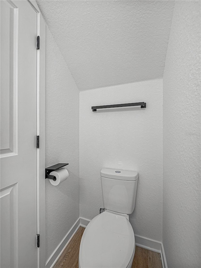 bathroom featuring hardwood / wood-style floors, toilet, and lofted ceiling