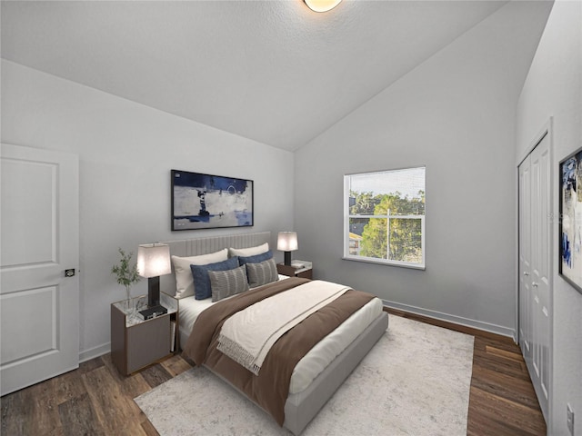 bedroom with dark hardwood / wood-style flooring, high vaulted ceiling, and a closet