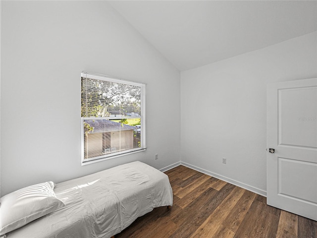 bedroom with high vaulted ceiling and dark hardwood / wood-style floors