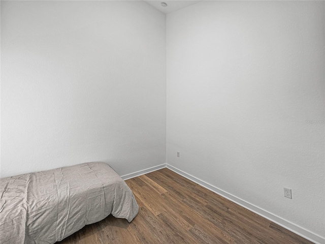 bedroom with dark wood-type flooring