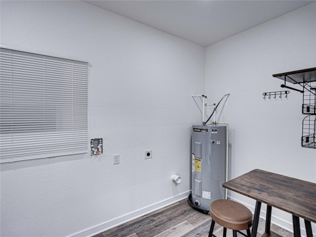 interior space featuring electric dryer hookup, wood-type flooring, and electric water heater