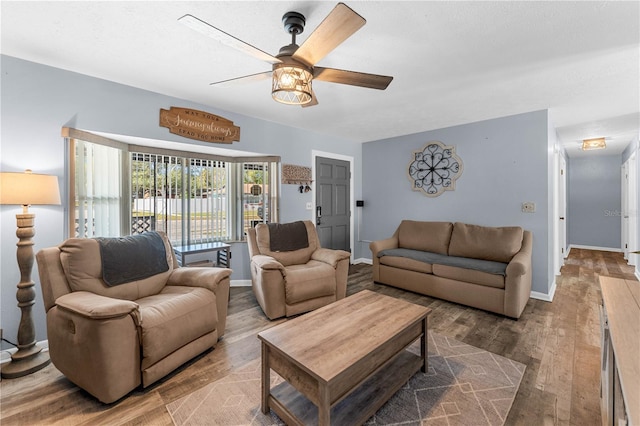 living room featuring ceiling fan and hardwood / wood-style floors