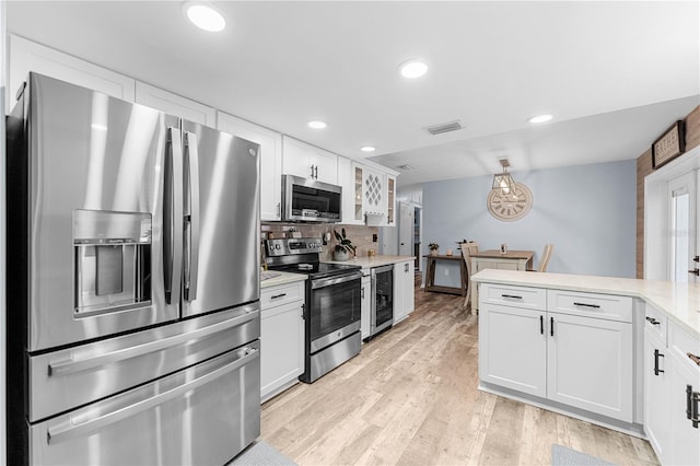 kitchen featuring white cabinetry, tasteful backsplash, wine cooler, appliances with stainless steel finishes, and light wood-type flooring