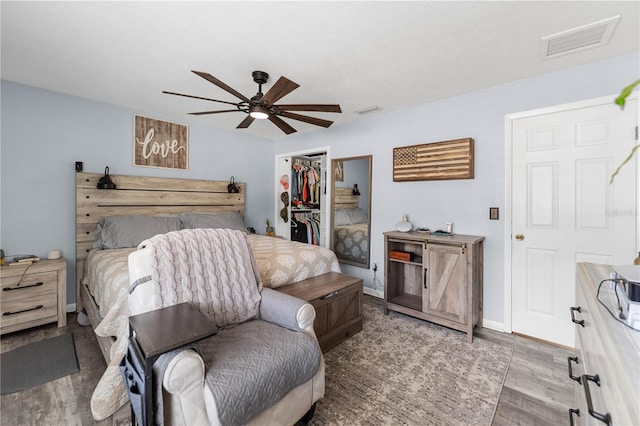 bedroom with a walk in closet, ceiling fan, a closet, and light hardwood / wood-style floors