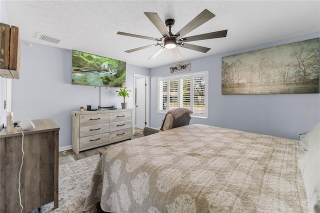 bedroom with ceiling fan and a textured ceiling