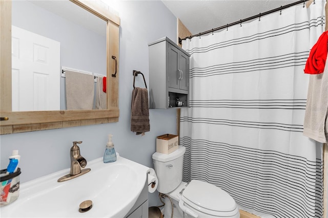 bathroom featuring vanity, curtained shower, toilet, and a textured ceiling