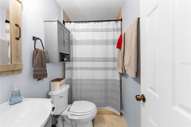 bathroom featuring walk in shower, sink, a textured ceiling, and toilet