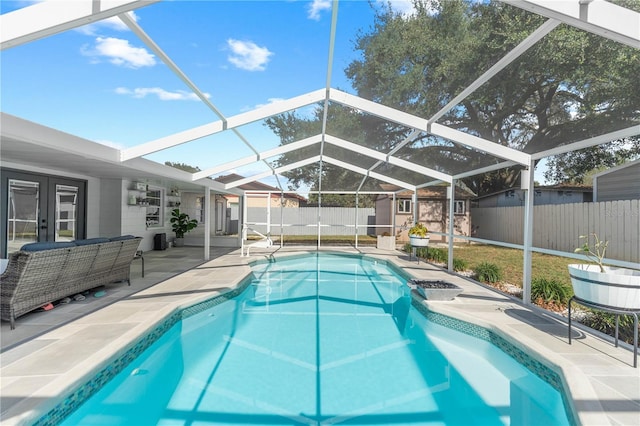 view of pool featuring a lanai, french doors, a storage unit, and a patio area