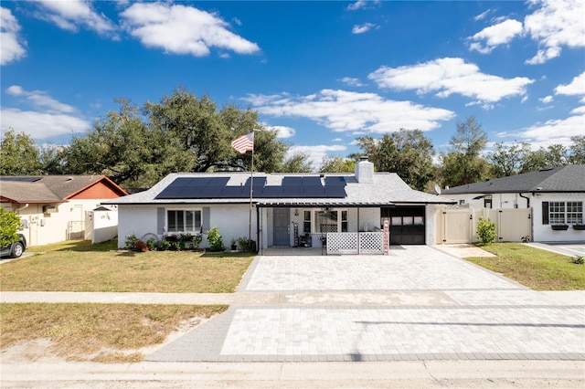 ranch-style home with solar panels, a porch, and a front lawn