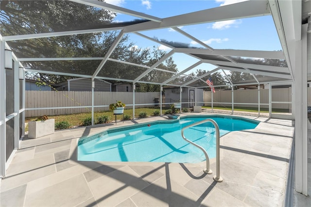 view of pool with a patio, glass enclosure, and a shed