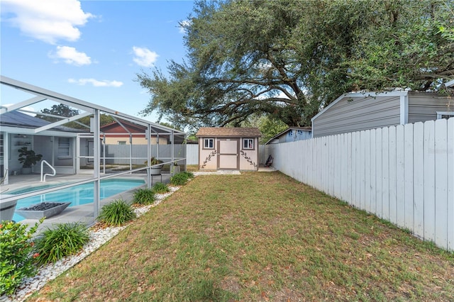 view of yard with a fenced in pool, glass enclosure, and a shed