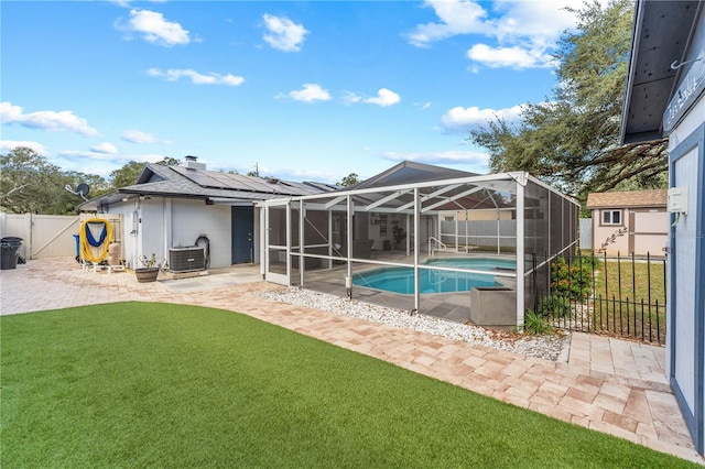 view of pool featuring a patio area, a yard, and glass enclosure